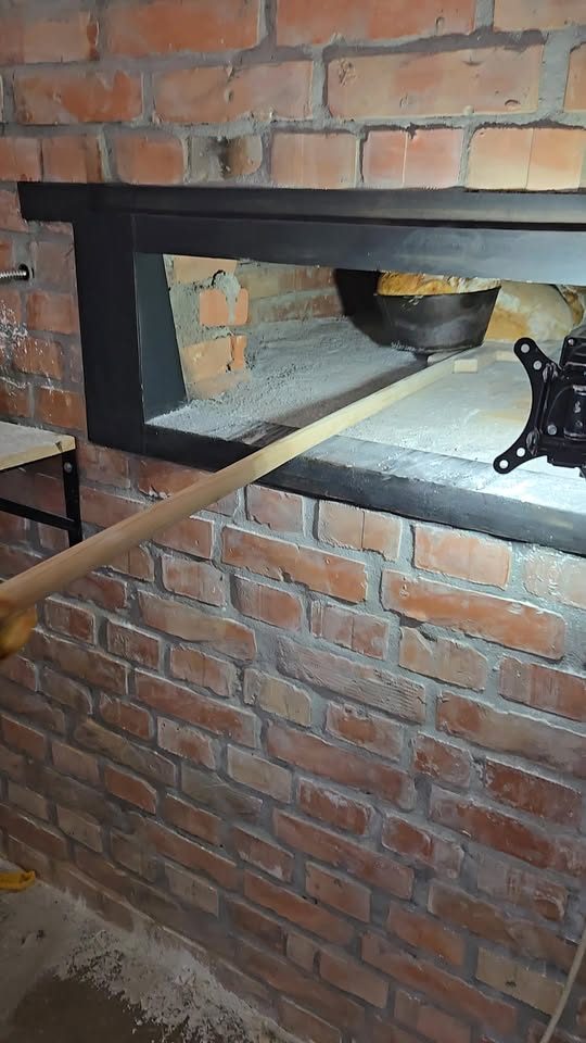 Lopata de lemn bagă pâinea în cuptorul cu vatră de cărămidă